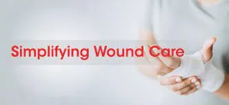 Hand and wrist wrapped in a white bandage dressing with the words Simplifying Wound Care